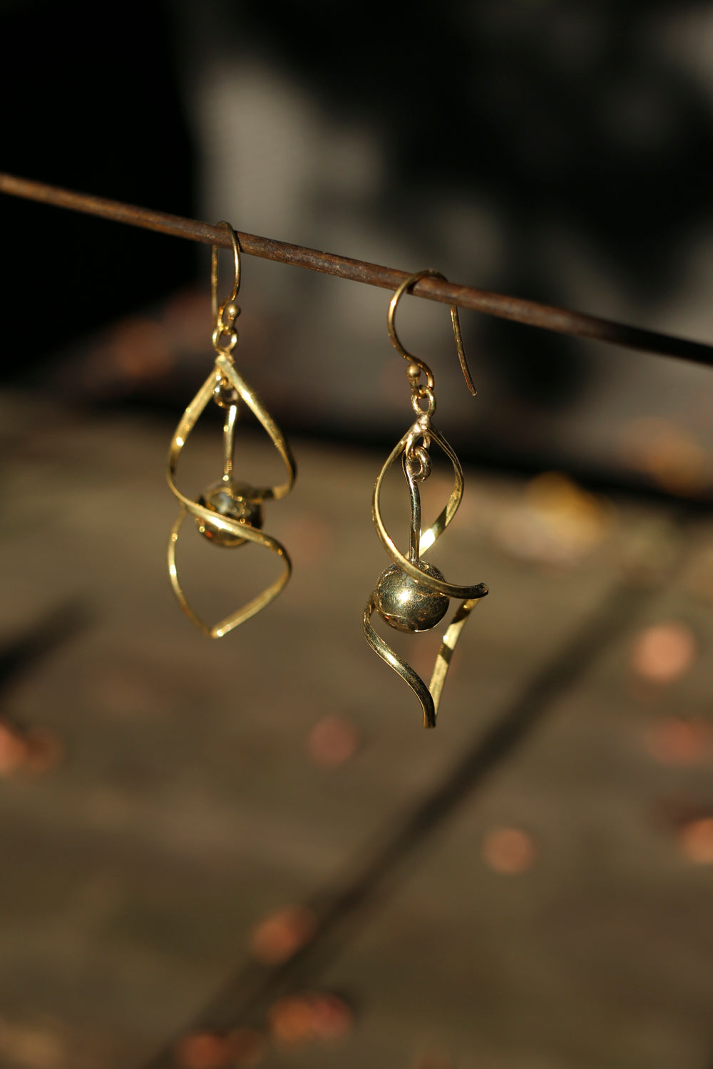 brass spiral earrings on a dark background