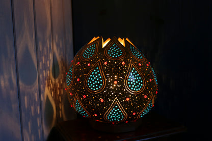 Decorative lamp with intricate patterns on a dark background