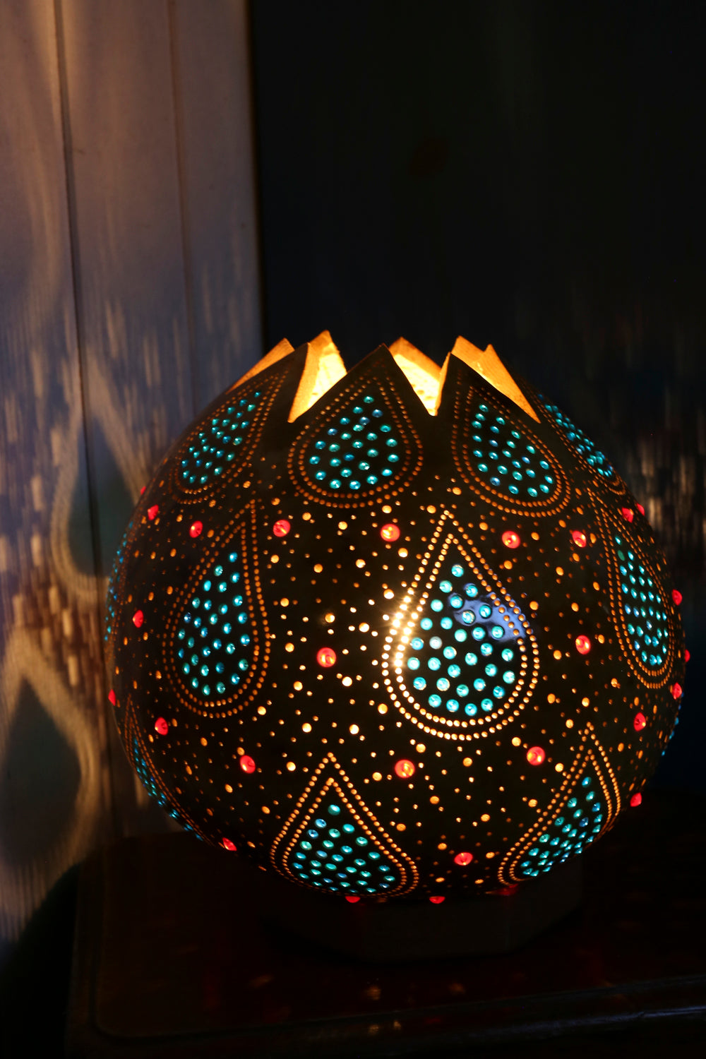 Decorative lamp with intricate patterns and colorful lights on a dark background