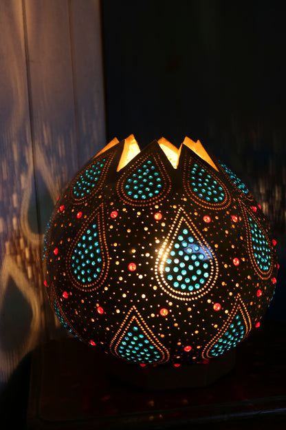 Decorative lamp with intricate patterns and colorful lights on a dark background