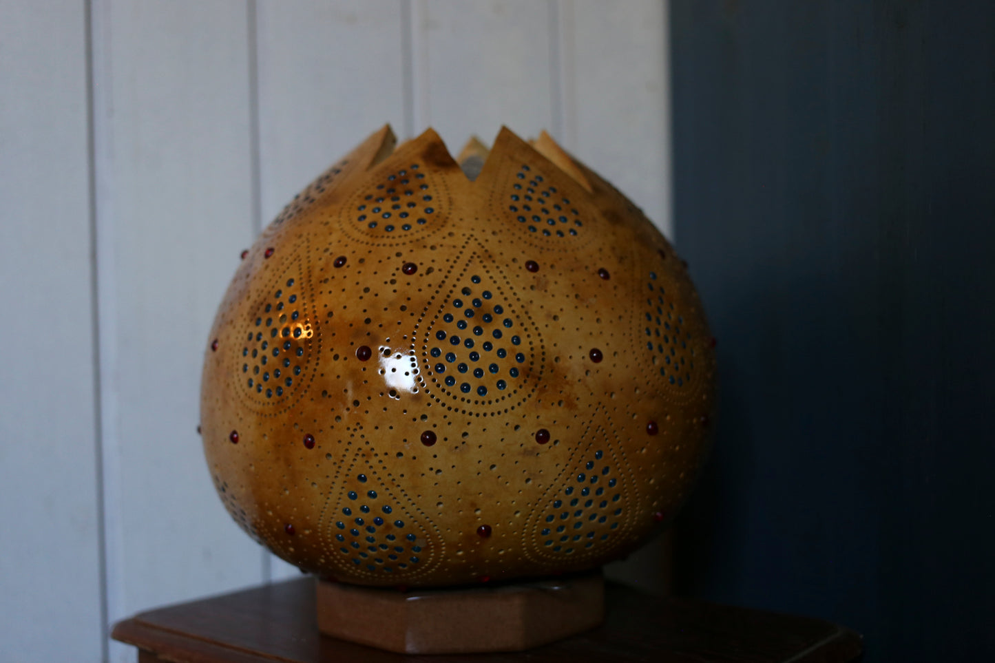 Decorative spherical lamp with intricate design on a wooden surface.