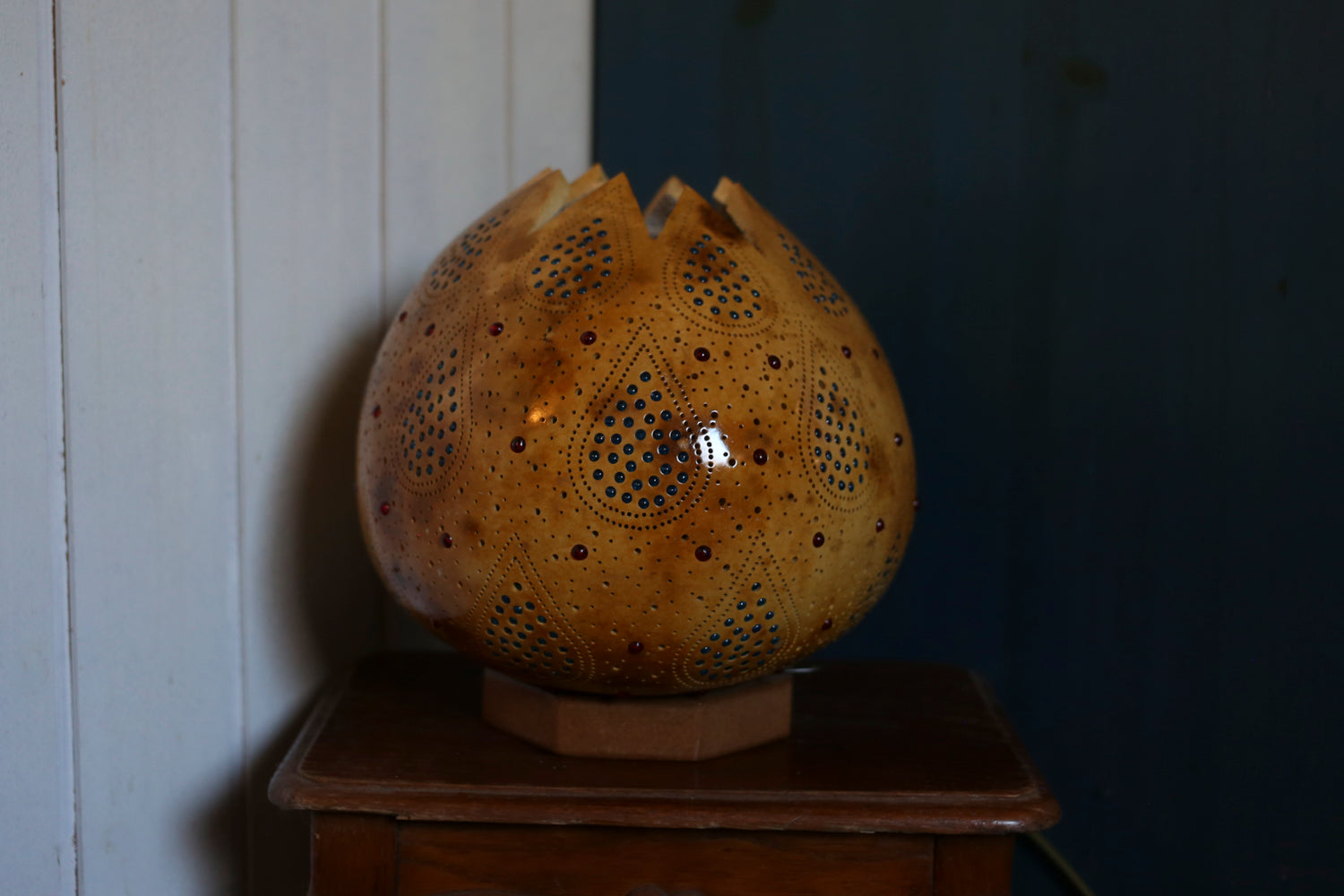 Decorative ceramic item with textured surface on a wooden surface against a wall.