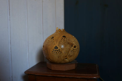 Decorative yellow sphere on a wooden surface against a white wall.