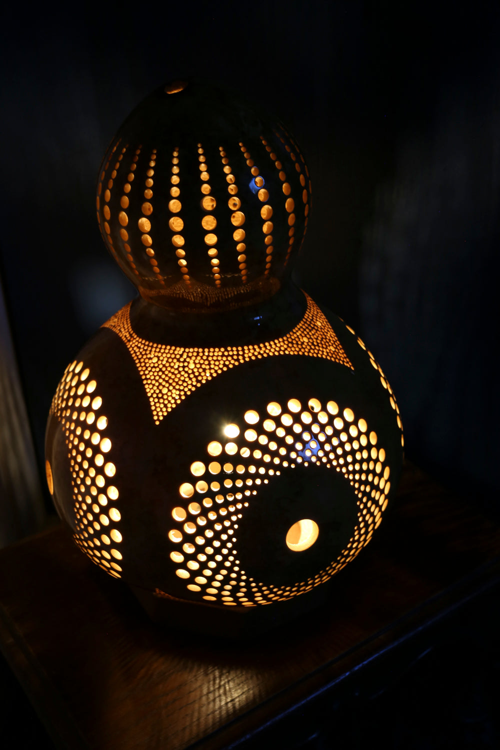 Decorative gourd lamp with intricate patterns on a dark background