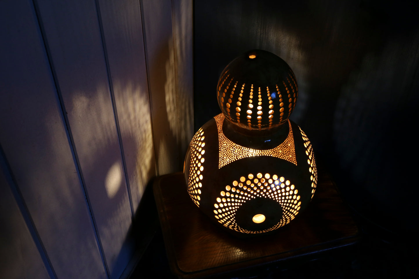 Decorative lamp with intricate patterns on a dark surface