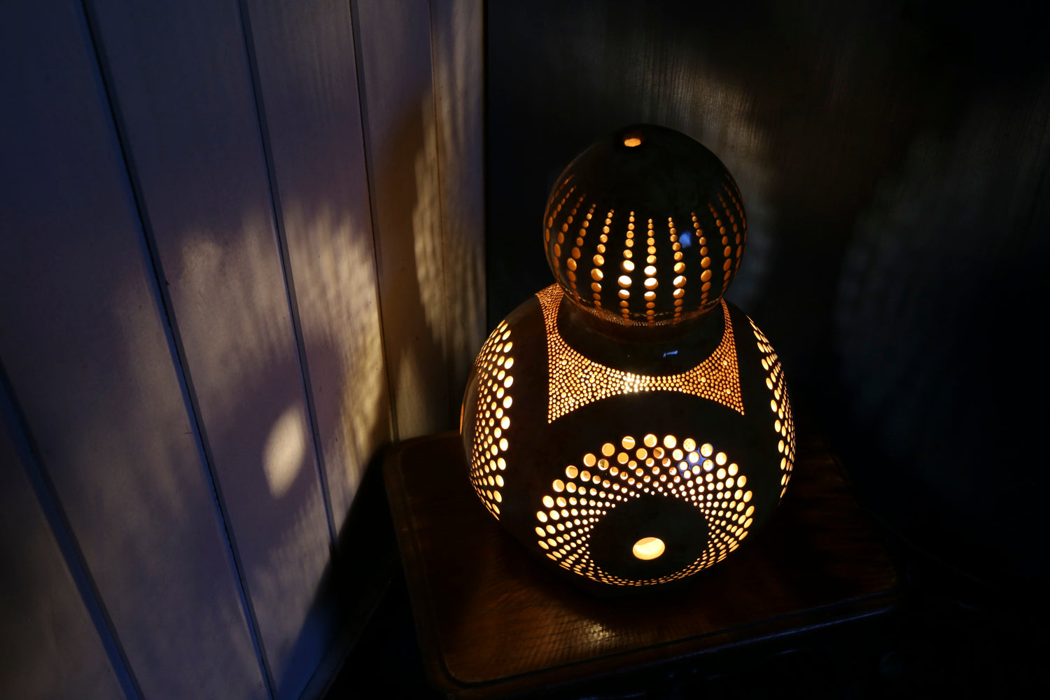 Decorative lamp with intricate patterns on a dark surface