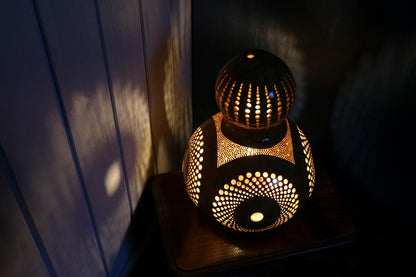 Decorative lamp with intricate patterns on a dark surface