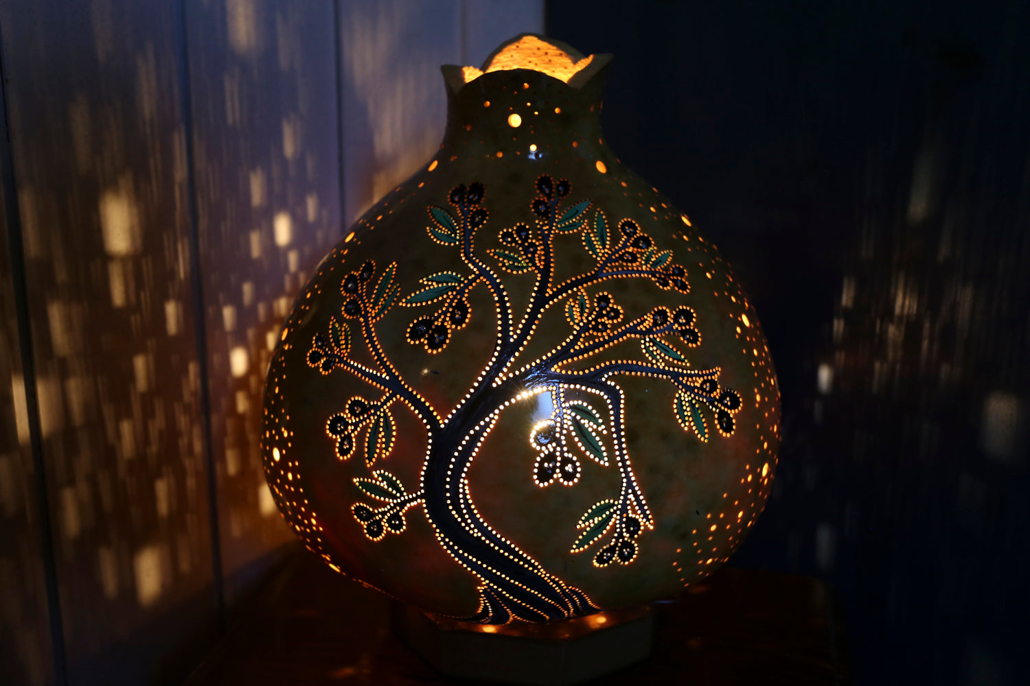 Decorative gourd with intricate patterns illuminated against a dark background