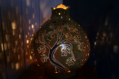 Decorative gourd with intricate patterns illuminated against a dark background