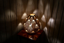Chargez l&#39;image dans la visionneuse de la galerie, Image of a handcrafted calabash lamp. The gourd&#39;s surface is intricately carved with patterns that allow soft light to shine through, creating a warm and inviting ambiance. The lamp is a blend of natural elegance and artistry, casting gentle shadows that enhance its beauty